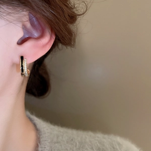 Detailed view of dual-layer C-shaped earrings with black enamel and zircon inlay