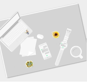 Sunflower stickers decorating laptop and accessories in a clean office setting