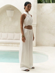 Detail of white linen halter top and wide-leg pants set showing natural fabric texture