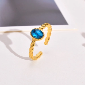 Detailed view of a gold twisted band open ring with an oval blue zircon gemstone