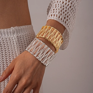 Detail of woven metallic wire wrap cuff bracelet in gold and silver finish