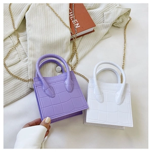 Detailed shot of purple and white mini crocodile pattern handbags with gold chains
