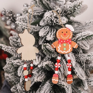 Christmas wooden gingerbread man ornament hanging on a snowy tree with red beads