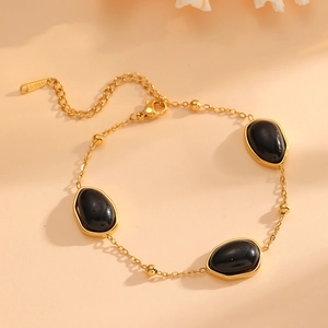 Dettaglio del bracciale in acciaio inossidabile dorato con opali neri e chiusura
