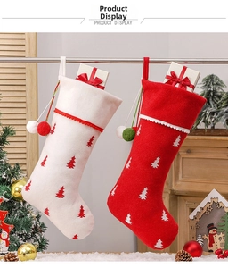 Macro detail of large Christmas stockings with tree prints and plush pom-poms on a tree