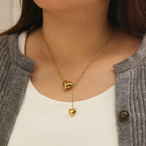 Minimalist gold stainless steel Y-shaped necklace with dual heart pendants worn by model