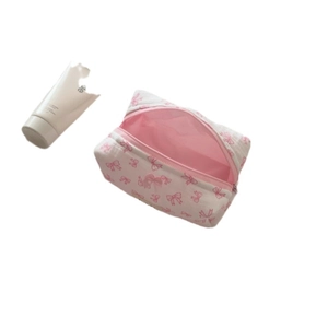 White cotton makeup bag with pink bow pattern and spacious interior for travel