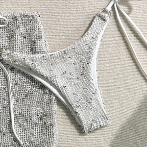 Detail of three-piece bikini set featuring unique beige textured grid mesh fabric