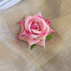 Detailed macro view of pink fabric rose hair clip petals with a natural gradient texture