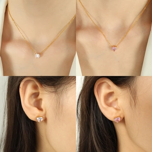 Elegant gold heart jewelry set with pink and white cubic zirconia on model