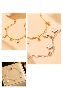 Detail of butterfly pendant bracelet with gold and silver finishes and white shell inlay