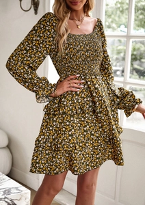 Detail view of the floral green dress featuring square neck design and elastic smocked bodice