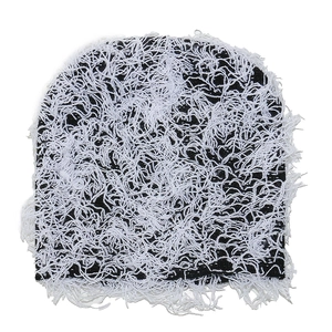 Detailed view of winter knit beanie featuring thick black fabric and white fringe texture