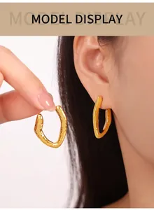 Close-up of gold-plated titanium earrings with unique hammered texture on model