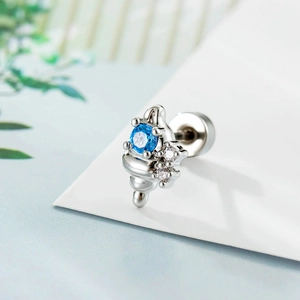 Silver conch stud earring with blue zircon and clear stones on a clean white card