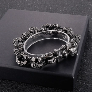 Detailed close-up of punk leopard and skull bracelet on a black gift box stand