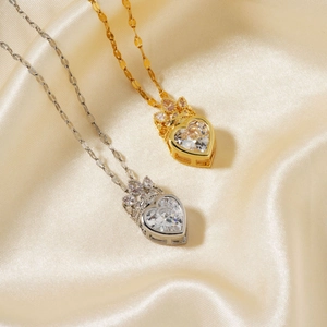 Dettaglio di pendenti a corona a cuore in oro e argento su elegante tessuto di seta