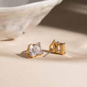 Dettaglio di orecchini a lobo in zircone a goccia e rettangolari placcati in oro 18K
