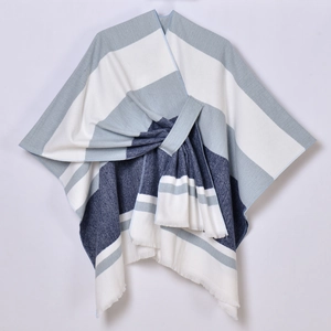 Detail view of blue white and grey striped poncho featuring elegant tassel fringe trim