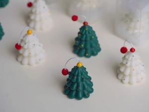 Detailed view of mini layered Christmas tree scented candle with colorful dot accents