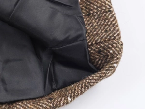 Détail du tissu en tweed à chevrons marron avec doublure noire sur un blazer chic