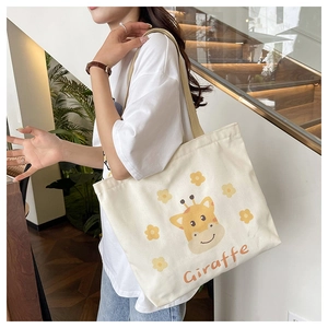 Close-up of cream canvas tote bag with cartoon giraffe and yellow flowers print