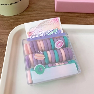 Macro shot of macaroon-colored elastic hair ties in a cereal-inspired gift box