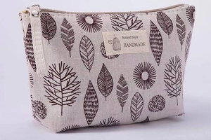 Detail of canvas toiletry bag featuring leaf patterns and a Natural Style woven label
