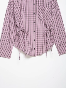 Détail de chemise à carreaux rose et noir avec cordon de serrage et boutons ronds