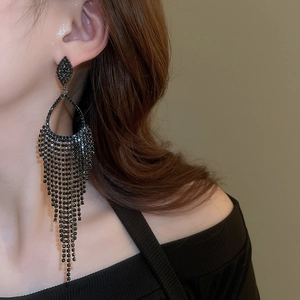 Detail of long black tassel earrings with sparkling rhinestones on model's ear