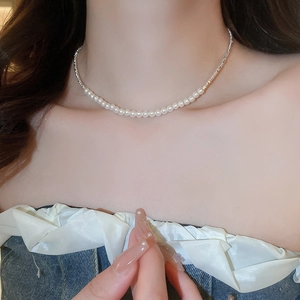 Close-up of pearl and silver chain necklace on model neck showing elegant texture