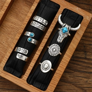 Detail of vintage silver western rings with turquoise on a leather roll inside a wooden box