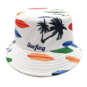 White reversible bucket hat with colorful surfing boards and palm tree prints for sun protection