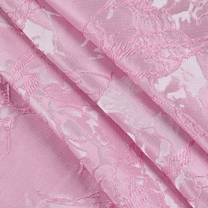 Close-up of pink jacquard fabric with elegant floral embroidery and woven texture