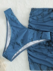Detail of blue marble print mesh fabric on high cut bikini bottom and ruched skirt