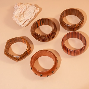 Macro detail of five ethnic style wooden bracelets with metal rivets and striped texture