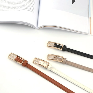 Flat lay of four minimalist thin leather belts for women in black and earth tones