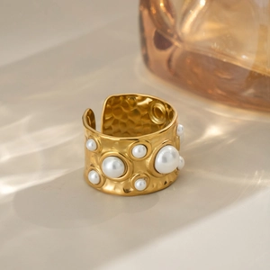 Détail de la bague en or martelé avec perles blanches et texture métallique unique