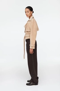 Side view of a beige faux suede cropped jacket with notched lapel and adjustable waist belt