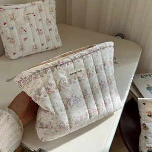 Detailed shot of a quilted cotton cosmetic bag with floral rabbit prints and simple wish label
