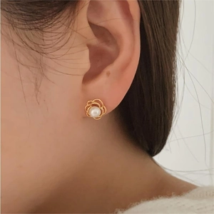 Detail view of a 925 sterling silver flower pearl earring worn on a model's ear