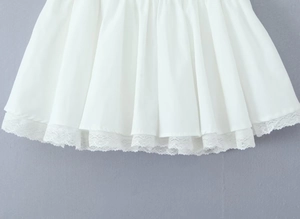 Détail de l'ourlet du jupon plissé blanc avec dentelle florale délicate et tissu soyeux