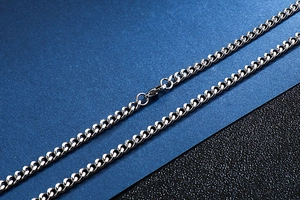 Macro shot of a classic silver stainless steel Cuban link chain necklace with lobster clasp
