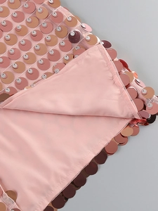 Macro shot of pink fish scale sequins on mesh fabric with smooth satin lining detail