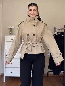 Détail du trench-coat court kaki à double boutonnage avec ceinture et col montant