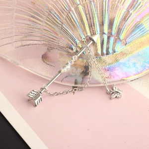 Silver industrial piercing arrow earring with butterfly charm and small chain detail
