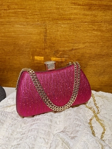 Sparkly rose red evening clutch bag with gold chain strap and rhinestone buckle close-up