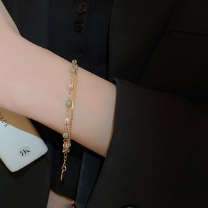 Detail of double-layer gold plated bracelet with colorful beads on female wrist