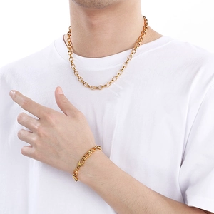 Detailed view of polished gold oval link chain necklace and bracelet set on a model