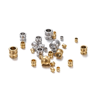 Detailed macro view of gold and silver stainless steel barrel beads for DIY jewelry